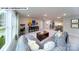 Bright, open living room with gray sectional sofa, decor, and view of the upstairs hallway at 144 Asmodean Ln, Troutman, NC 28166