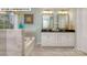 Well-lit bathroom featuring a soaking tub, dual vanities, granite countertops, and tile flooring at 146 Asmodean Ln, Troutman, NC 28166