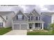 Charming two-story home featuring a symmetrical facade, a two-car garage, and manicured landscaping at 146 Asmodean Ln, Troutman, NC 28166
