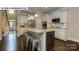 Open kitchen boasts a center island with seating, stainless appliances, and hardwood floors throughout at 146 Asmodean Ln, Troutman, NC 28166
