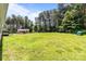Spacious backyard featuring a lush green lawn and an outbuilding, all surrounded by mature trees and privacy at 151 Lillyfield Dr, Rockwell, NC 28138