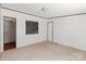 White bedroom showcasing a window overlooking a lawn and neutral carpeting at 151 Lillyfield Dr, Rockwell, NC 28138