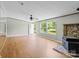 Bright living room with a ceiling fan, windows with a view, a stone fireplace, and wood floors at 151 Lillyfield Dr, Rockwell, NC 28138