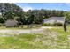 Backyard featuring a fenced in yard, two outbuildings, and a gravel driveway, with many mature trees at 151 Lillyfield Dr, Rockwell, NC 28138