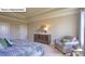 Bedroom featuring tray ceilings, neutral walls, a gray accent chair, and a wooden dresser with decor at 160 Asmodean Ln, Troutman, NC 28166
