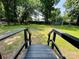 A grassy backyard with a wooden fence viewed from a deck's stairs at 20016 Walter Henderson Rd, Cornelius, NC 28031