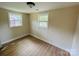 This is a bedroom with wood flooring, two windows, and neutral colored walls at 20016 Walter Henderson Rd, Cornelius, NC 28031