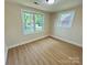 This is a bedroom with wood flooring, two windows, and neutral colored walls at 20016 Walter Henderson Rd, Cornelius, NC 28031