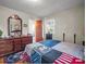 Bedroom with hardwood floors, a window for natural light, dresser with mirror, and an open bathroom door at 202 College Ave, Shelby, NC 28152