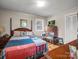 Bedroom with a bed, dresser, and window offering natural light; includes hardwood flooring and simple decor at 202 College Ave, Shelby, NC 28152