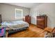 Bedroom with hardwood floors, a large bed, two dressers, a window and closet doors, offering ample storage at 202 College Ave, Shelby, NC 28152