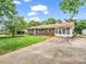 A ranch style home with brick and glass, and a long driveway on a grassy lot at 202 College Ave, Shelby, NC 28152