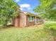 Side view of a brick home with green shutters and large trees at 202 College Ave, Shelby, NC 28152