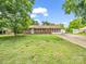 Charming brick home with green shutters, mature trees, and a spacious front yard at 202 College Ave, Shelby, NC 28152