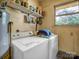 Functional laundry room featuring a washer, dryer, water heater, and window providing natural light at 202 College Ave, Shelby, NC 28152