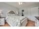 Bright bedroom with a white bed frame, floral bedding, wood floors, and a ceiling fan at 2023 E Park Dr, Lancaster, SC 29720