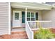 Close-up of the front porch featuring brick steps and a white railing at 2023 E Park Dr, Lancaster, SC 29720