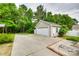 Spacious driveway and detached garage surrounded by lush trees in the backyard at 2023 E Park Dr, Lancaster, SC 29720