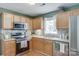 Updated kitchen with stainless steel appliances, wood cabinets, and stylish backsplash at 2023 E Park Dr, Lancaster, SC 29720