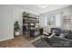 Well-lit home office is furnished with a desk, shelving unit, and comfortable seating for a productive workspace at 2045 Mantle Ridge Dr, Indian Trail, NC 28079