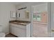 Bathroom with granite vanity, dual sinks, lighting fixtures, and open doorway at 2809 N Main St, Kannapolis, NC 28081