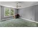 A bedroom with a window overlooking green trees, complemented by gray walls and a ceiling fan at 2809 N Main St, Kannapolis, NC 28081