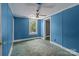 The blue bedroom features a window that brings the beauty of the outdoors inside and a ceiling fan at 2809 N Main St, Kannapolis, NC 28081
