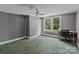 A bedroom with a window overlooking green trees, complemented by gray walls and a ceiling fan at 2809 N Main St, Kannapolis, NC 28081