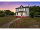 Two-story home with a red porch, white siding and a gazebo, set against a colorful sunset sky at 2809 N Main St, Kannapolis, NC 28081