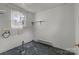 A simple laundry room featuring tile floors, a window, and peeling paint at 2809 N Main St, Kannapolis, NC 28081