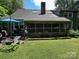 View of the back of the house with a screened in porch and a stone patio at 2815 Penny Park Dr, Gastonia, NC 28052