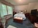 Bedroom featuring carpeted floors, window with blind, wooden dresser and TV at 2815 Penny Park Dr, Gastonia, NC 28052