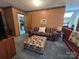 A cozy bonus room with a plaid couch and an ottoman next to the wooden railing at 2815 Penny Park Dr, Gastonia, NC 28052