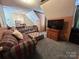 Carpeted bonus room with comfy plaid couch, ottoman, and wooden railing at 2815 Penny Park Dr, Gastonia, NC 28052