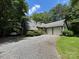 Exterior view of the home features a carport and two-car garage, surrounded by lush greenery at 2815 Penny Park Dr, Gastonia, NC 28052