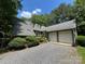 Charming exterior featuring a gray roof, gravel driveway, and a two-car garage with green wood details at 2815 Penny Park Dr, Gastonia, NC 28052