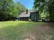 Green two-story home featuring a screened-in porch, chimney, and a spacious lawn surrounded by trees at 2815 Penny Park Dr, Gastonia, NC 28052
