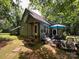 Quaint home with a back patio with seating surrounded by greenery and shady trees at 2815 Penny Park Dr, Gastonia, NC 28052