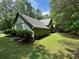 Green home exterior featuring lush landscaping, complemented by mature trees for added privacy at 2815 Penny Park Dr, Gastonia, NC 28052
