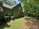 Green home exterior showcasing well-maintained landscaping and a tranquil wooded backdrop at 2815 Penny Park Dr, Gastonia, NC 28052