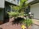 Exterior view of a green home highlighting a garden bed and a cozy outdoor seating area at 2815 Penny Park Dr, Gastonia, NC 28052