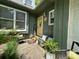 Inviting front porch with plants, seating, a yellow door, and 'Welcome' sign for a warm, cozy entryway at 2815 Penny Park Dr, Gastonia, NC 28052