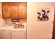 Laundry room with washer, dryer, and overhead wood cabinets, offering ample storage space at 2815 Penny Park Dr, Gastonia, NC 28052