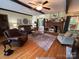 Spacious living room with hardwood floors, a brick fireplace, dark wood beams, and comfortable furniture at 2815 Penny Park Dr, Gastonia, NC 28052