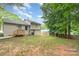 Large backyard features a patio and green space surrounded by mature trees offering privacy and shade at 3121 Revolution Park Dr, Charlotte, NC 28217