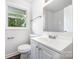 Bright bathroom with a large mirror, single sink vanity, new fixtures, and a window that gives natural light at 3121 Revolution Park Dr, Charlotte, NC 28217