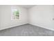 Clean and tidy bedroom with neutral carpet and paint and a large window providing natural lighting at 3121 Revolution Park Dr, Charlotte, NC 28217