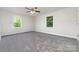 Spacious bedroom with neutral carpet, two large windows that give great natural light and a ceiling fan at 3121 Revolution Park Dr, Charlotte, NC 28217