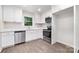 Modern kitchen featuring gray tile floors, stainless steel appliances, white cabinets and quartz countertops at 3121 Revolution Park Dr, Charlotte, NC 28217
