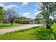 Traditional home with brick accents and a long driveway leading to a detached carport, surrounded by lush greenery at 319 Glenhaven Dr, Charlotte, NC 28214